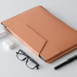 MOFT - Laptop Carry Sleeve 輕薄三合一 隱形立架筆電包 in a stylish tan color, placed on a simple desk with glasses and a pen.